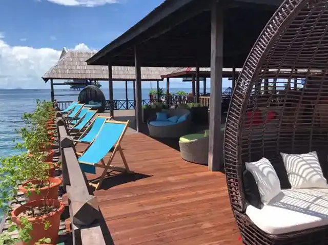 Jetty lounge with deck chairs and sofas above the sea at Borneo Divers Mabul Resort