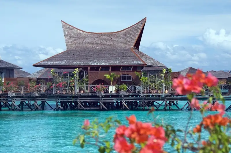 Borneo Villa Suite at Mabul Water Bungalows: timber villa with a curved shingle roof over the water