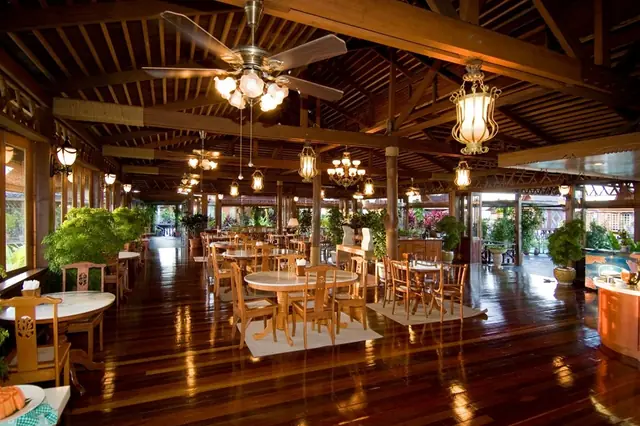 Restaurant at Mabul Water Bungalows: timber hall with dining tables, lanterns and ceiling fans