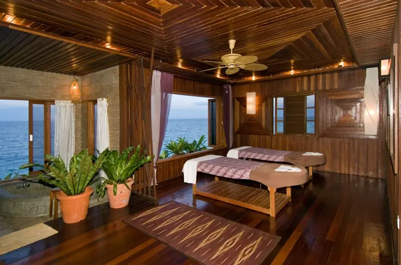 Spa room at Mabul Water Bungalows with two massage beds and windows onto the sea